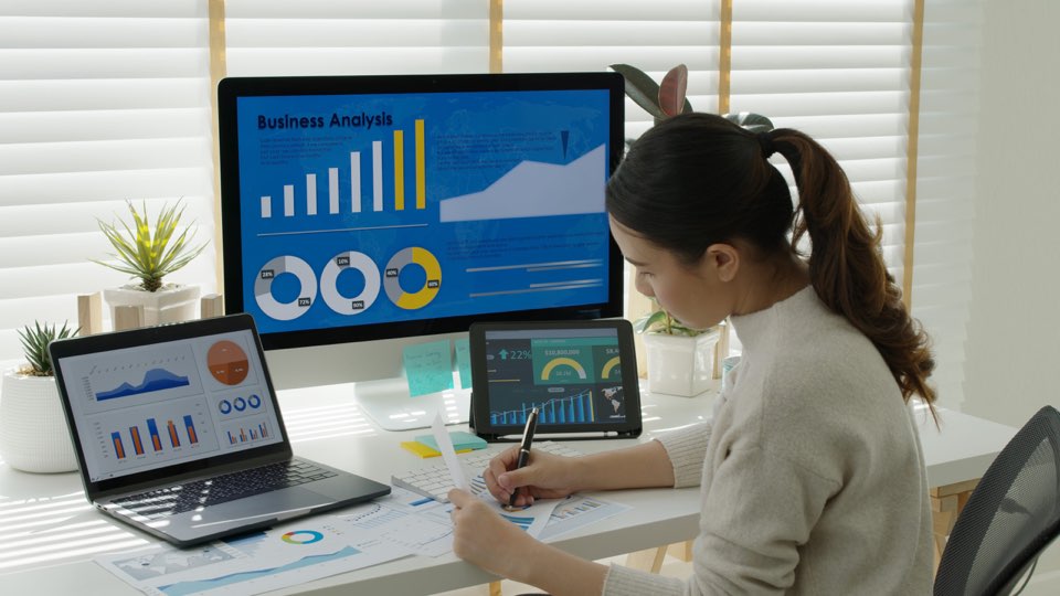 Woman working on multiple computers